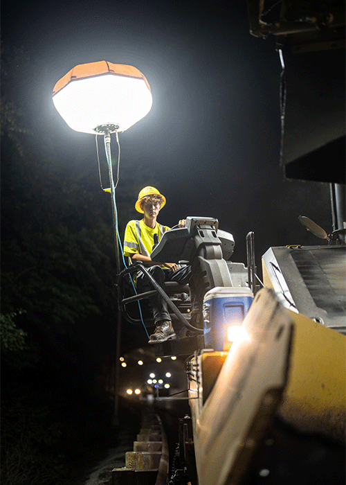 An LPC worker sits atop heavy machinery on a night job in KY