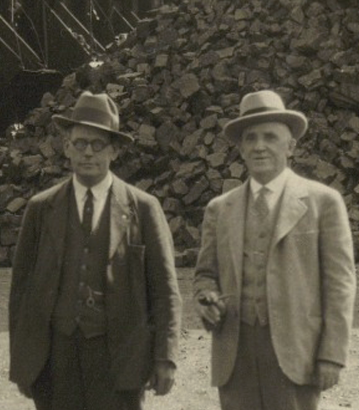 Founders of Dougherty Coal Company stand in front of construction material