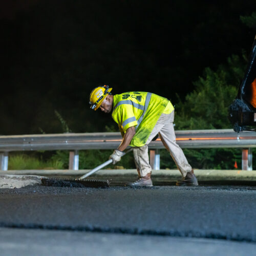 An LPC worker engages in asphalt milling on a highway at night in Kentuckiana