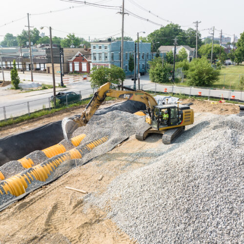 A crane shovels gravel on a construction site for LPC in Kentuckiana