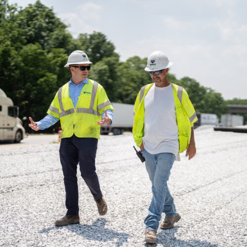 Two construction workers walk together in their PPE in Kentuckiana