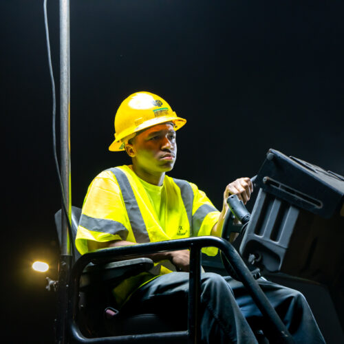 A construction worker sits on a heavy civil tractor during a night time construction job in Kentuckiana