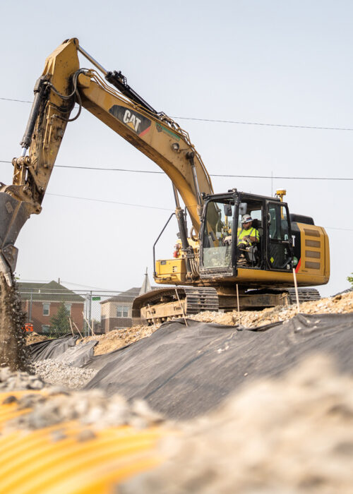 A crane drops dirt on an excavation site in Kentuckiana